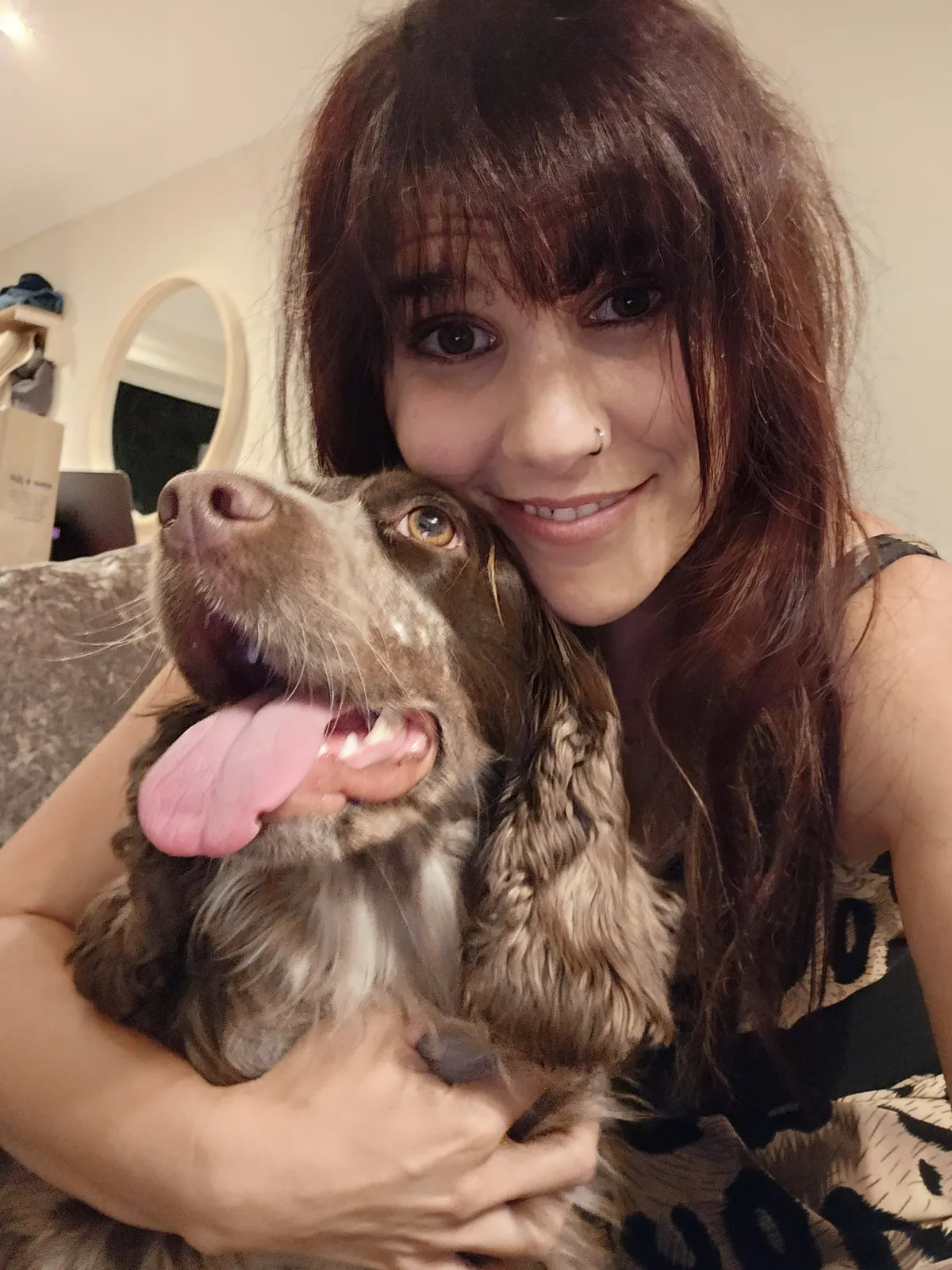 A sitter cuddles a spotted Cocker Spaniel cheek to cheek